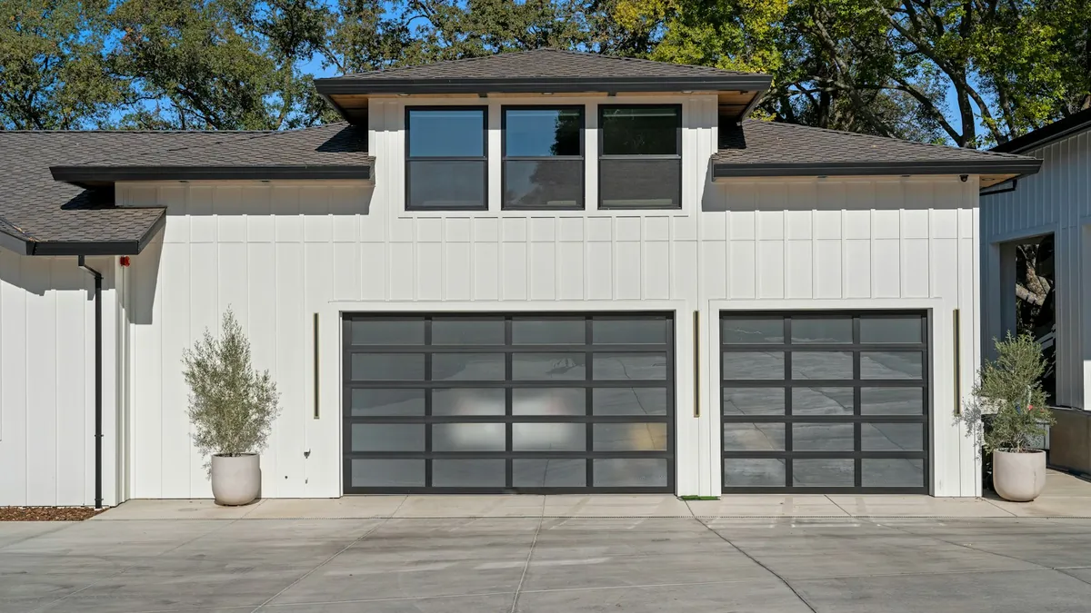 Modern residential home with two garage doors and a wide driveway