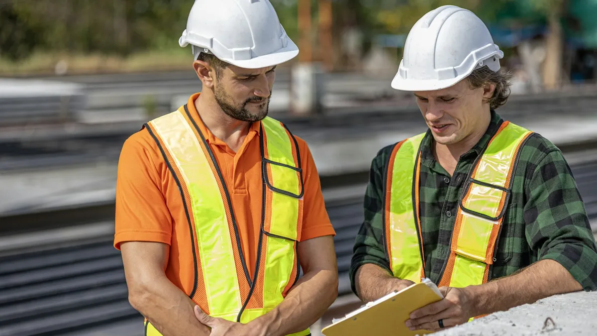 Two construction professionals reviewing plans at a job site