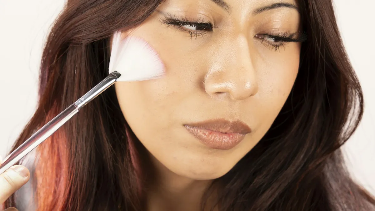 Aesthetician applying a fan brush during a facial treatment