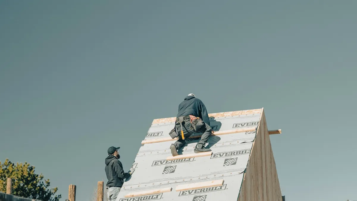 Construction workers building a residential roof structure during a renovation