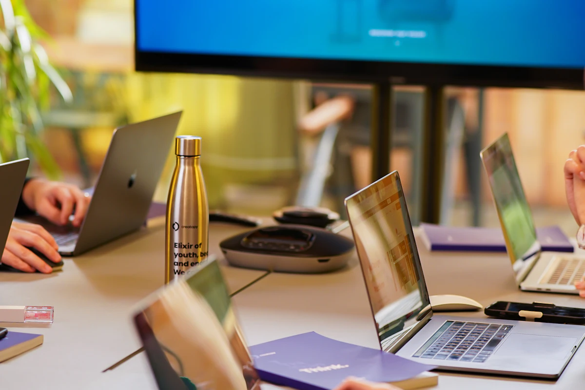 Team working with laptops around a meeting table
